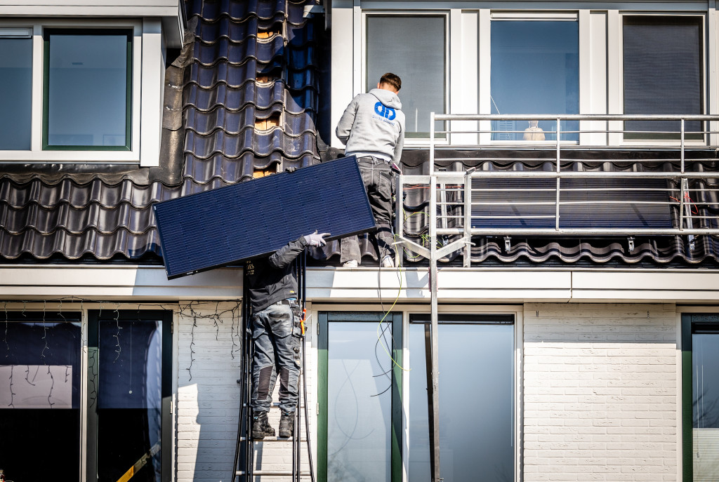 Zonnepanelen worden op het dak van een woning geïnstalleerd.