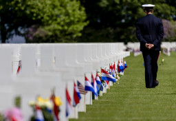 Een militair loopt over de begraafplaats tijdens de jaarlijkse Memorial Day herdenking bij op de Amerikaanse begraafplaats in Margraten.