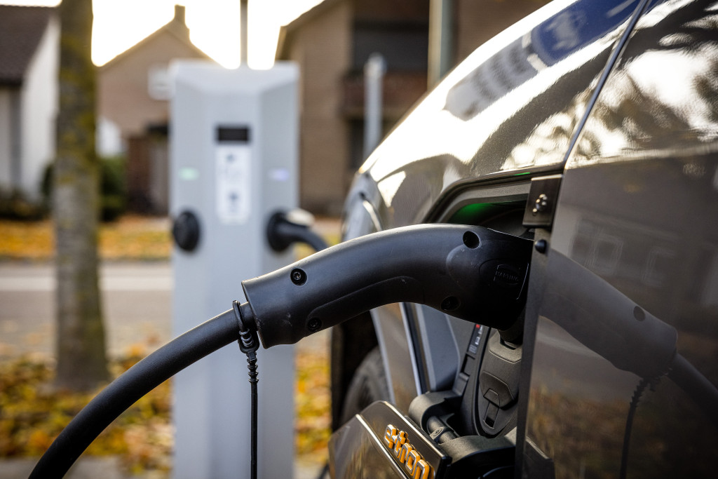 Een elektrische auto wordt opgeladen aan een openbare laadpaal.