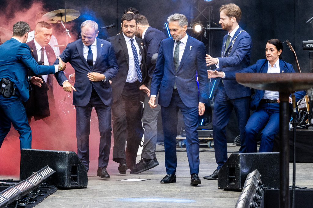 Premier Dick Schoof en zijn ambtsgenoot Donald Tusk van Polen worden in veiligheid gebracht als demonstranten een rookbom gooien bij het ontsteken van het Bevrijdingsvuur.