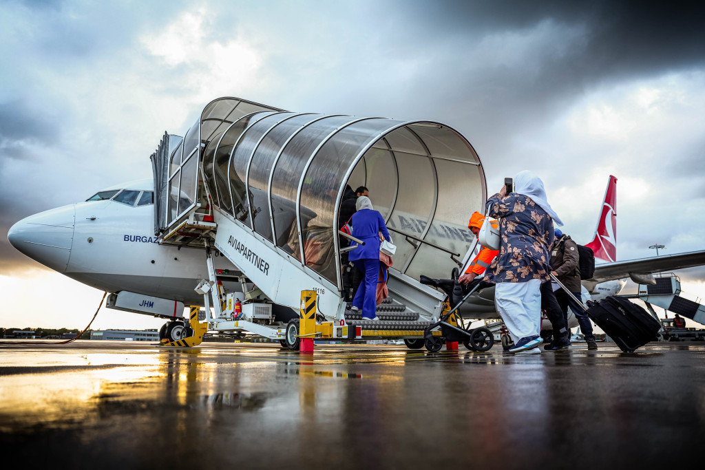 Mensen met een Syrische nationaliteit stappen in een vliegtuig voor vertrek richting Damascus.