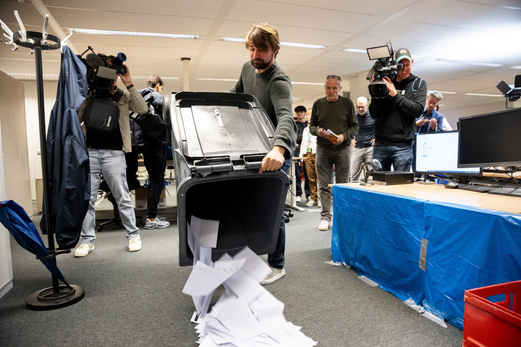 Stembureauleden tellen in het stadsdeelkantoor de briefstemmen die door kiesgerechtigden uit het buitenland zijn ingevuld en waren verzameld bij consulaten en ambassades.