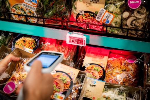 Een klant met een zelfscanner bij supermarkt Albert Heijn.