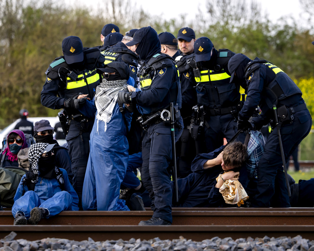 Politieagenten van de Mobiele Eenheid grijpen in tijdens een blokkade van de Betuweroute door activisten van Geef Tegengas.