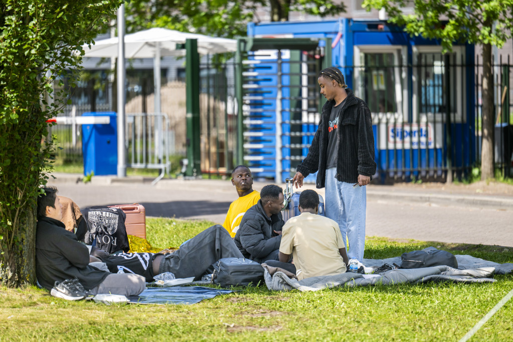 Asielzoekers bij het aanmeldcentrum, waar de opvanglocatie overvol is.