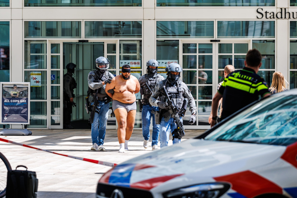 Het team van de politie heeft een man aangehouden in het stadhuis. Hij werd met een zwarte blinddoek om naar buiten gevoerd.